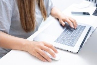 Teenager using a laptop on a desk